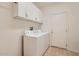 Functional laundry room with ample cabinet storage and a washer and dryer at 17009 W Eureka Springs Dr, Surprise, AZ 85387