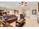 Spacious living room with leather sofas, ceiling fan, and open floor plan at 17009 W Eureka Springs Dr, Surprise, AZ 85387