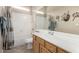Neutral bathroom with a shower/tub combo, neutral tile floor, a large mirror, and wooden cabinetry at 18247 N 168Th Cir, Surprise, AZ 85374