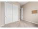 Empty bedroom with carpeted floors, neutral walls, a closet, and access to another room at 18247 N 168Th Cir, Surprise, AZ 85374