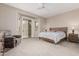 A bright, carpeted primary bedroom with a ceiling fan, a sitting area, and sliding door access to the outdoors at 18247 N 168Th Cir, Surprise, AZ 85374