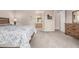 Carpeted bedroom featuring a wooden bed frame, neutral-colored walls, and a peek into the attached bathroom at 18247 N 168Th Cir, Surprise, AZ 85374