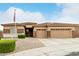 Welcoming home featuring a well-manicured yard with stone accents and a spacious three-car garage at 18247 N 168Th Cir, Surprise, AZ 85374