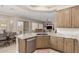 Gourmet kitchen featuring stainless steel appliances, light wood cabinetry, and an open view of the living room at 18247 N 168Th Cir, Surprise, AZ 85374