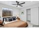 Modern bedroom features a ceiling fan, closet, and a window with blinds for natural light at 1962 E Morrow Dr, Phoenix, AZ 85024