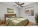 Serene bedroom with a wood-frame bed, a ceiling fan, and ample natural light from the window at 1962 E Morrow Dr, Phoenix, AZ 85024