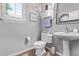 Bathroom features a pedestal sink, toilet, and a bright window at 19903 S 187Th Dr, Queen Creek, AZ 85142