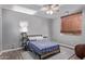 Well-lit bedroom with a ceiling fan, bed, carpet, and a window with decorative shades at 19903 S 187Th Dr, Queen Creek, AZ 85142