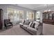 Bright living room featuring a comfortable sofa, shuttered windows, and an open floor plan with stylish décor at 19903 S 187Th Dr, Queen Creek, AZ 85142
