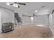 Spacious living room featuring wood floors, ceiling fans, and a staircase leading to the upper level at 19903 S 187Th Dr, Queen Creek, AZ 85142