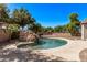 Backyard pool with a rock waterfall feature and surrounding landscaping at 19903 S 187Th Dr, Queen Creek, AZ 85142