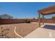 Exterior backyard view with low-maintenance landscaping and partial covered patio at 23929 W Twilight Trl, Buckeye, AZ 85326