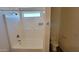 Bathroom featuring a toilet, tub, and shower combo with a window at 23929 W Twilight Trl, Buckeye, AZ 85326