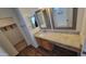 Well-lit bathroom featuring dual mirrors, granite vanity with drawers, and wood-look flooring at 23929 W Twilight Trl, Buckeye, AZ 85326