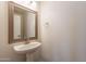 Bathroom features a pedestal sink, framed mirror, and neutral wall paint at 23929 W Twilight Trl, Buckeye, AZ 85326