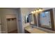 Well-lit bathroom featuring dual mirrors, granite vanity, and an enclosed toilet area at 23929 W Twilight Trl, Buckeye, AZ 85326
