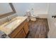 Modern bathroom featuring granite vanity, white fixtures, and wood-look flooring at 23929 W Twilight Trl, Buckeye, AZ 85326