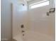 Relaxing bathtub and shower space, complemented by tiled walls and a bright window at 23929 W Twilight Trl, Buckeye, AZ 85326