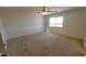 Bright, spacious bedroom with neutral carpet flooring, ceiling fan, and a window for natural light at 23929 W Twilight Trl, Buckeye, AZ 85326