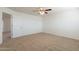 Spacious bedroom with neutral carpet, ceiling fan and a convenient entry door at 23929 W Twilight Trl, Buckeye, AZ 85326