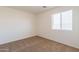 Bedroom featuring neutral carpet, a window with blinds, and ample natural light at 23929 W Twilight Trl, Buckeye, AZ 85326