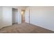 Bedroom with neutral carpet, an open door and closet creating inviting and organized space at 23929 W Twilight Trl, Buckeye, AZ 85326