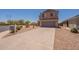 Two-story home featuring a neutral stucco exterior, gray garage door, and low-maintenance landscaping at 23929 W Twilight Trl, Buckeye, AZ 85326