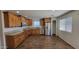 Modern kitchen featuring wood cabinets, granite countertops, and stainless steel appliances, complemented by wood flooring at 23929 W Twilight Trl, Buckeye, AZ 85326