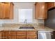 Close up of a kitchen, with wood cabinets, granite countertops, and stainless steel appliances at 23929 W Twilight Trl, Buckeye, AZ 85326