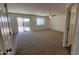 Bright living room with carpet flooring, ceiling fan, and a sliding door leading to the backyard at 23929 W Twilight Trl, Buckeye, AZ 85326