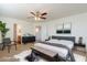 Staged main bedroom with neutral walls, carpet, and ceiling fan at 23929 W Twilight Trl, Buckeye, AZ 85326