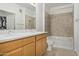 Bright bathroom featuring double sinks, light wood cabinets, and tiled shower-tub combination at 2511 W Queen Creek Rd # 378, Chandler, AZ 85248