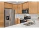 Modern kitchen with stainless steel appliances, light wood cabinets, and quartz countertops at 2511 W Queen Creek Rd # 378, Chandler, AZ 85248