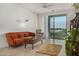 Modern living room featuring an orange sofa, coffee table with chess, and access to a balcony at 2511 W Queen Creek Rd # 378, Chandler, AZ 85248