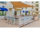 Outdoor kitchen with barstool seating at a light countertop, stainless steel grills and shade awning at 2511 W Queen Creek Rd # 378, Chandler, AZ 85248