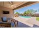 Covered patio with outdoor furniture overlooking a swimming pool, artificial turf, and desert landscaping at 2543 W Rabjohn Rd, Phoenix, AZ 85085