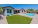 Spacious backyard with a pool, artificial turf, lounge chairs, and desert landscaping at 2543 W Rabjohn Rd, Phoenix, AZ 85085