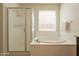 Bright bathroom featuring a shower and tub, with neutral tones and natural light at 2543 W Rabjohn Rd, Phoenix, AZ 85085