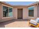 Inviting front courtyard with neutral tones, a seating area, and large windows flanking the front door at 2543 W Rabjohn Rd, Phoenix, AZ 85085