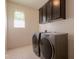 Functional laundry room equipped with modern washer and dryer units and ample storage at 2543 W Rabjohn Rd, Phoenix, AZ 85085