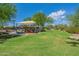 Neighborhood playground featuring shade and seating surrounded by green grass and trees at 2543 W Rabjohn Rd, Phoenix, AZ 85085