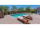 Backyard pool with chaise lounges on a brick patio surrounded by mature landscaping and a black fence at 2543 W Rabjohn Rd, Phoenix, AZ 85085