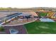 Aerial view of a community park with playground, picnic areas, basketball court, and green spaces at 25467 W Graham Trl, Buckeye, AZ 85326