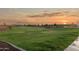 Lush community park with green lawns, walking paths, and mature trees under a beautiful sunset at 25467 W Graham Trl, Buckeye, AZ 85326