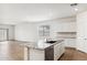 Open-concept kitchen with a large island, wood flooring, and bright lighting at 25467 W Graham Trl, Buckeye, AZ 85326