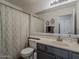 Bathroom features a large mirror, gray cabinets, and a shower with patterned curtain at 2550 E Caballero St, Mesa, AZ 85213