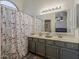 Stylish bathroom featuring double sinks, gray cabinets, and a large mirror at 2550 E Caballero St, Mesa, AZ 85213