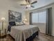 Comfortable bedroom with a ceiling fan, wood floors, and a large window for natural light at 2550 E Caballero St, Mesa, AZ 85213