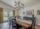 Dining room featuring wood-look tile flooring, a modern chandelier, and views of the outdoor space at 2550 E Caballero St, Mesa, AZ 85213