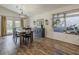 Bright dining area with wood-look tile flooring, a modern light fixture, and views of an inviting outdoor space at 2550 E Caballero St, Mesa, AZ 85213